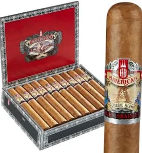 Single Alec Bradley American Classic cigar with smooth brown wrapper, placed in front of an open box filled with cigars.