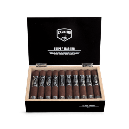Open box of Camacho Triple Maduro cigars with dark wrappers and bold black-and-silver bands