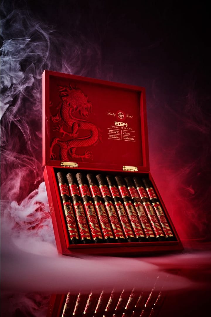 Open box of Rocky Patel Year of the Dragon cigars with elegantly arranged cigars and vibrant packaging.