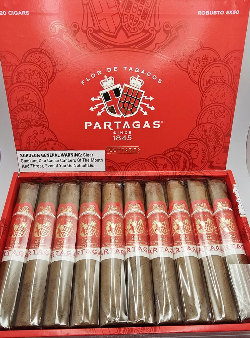 Open box of Partagás Cortado cigars with smooth, light-colored wrappers and gold-accented bands.