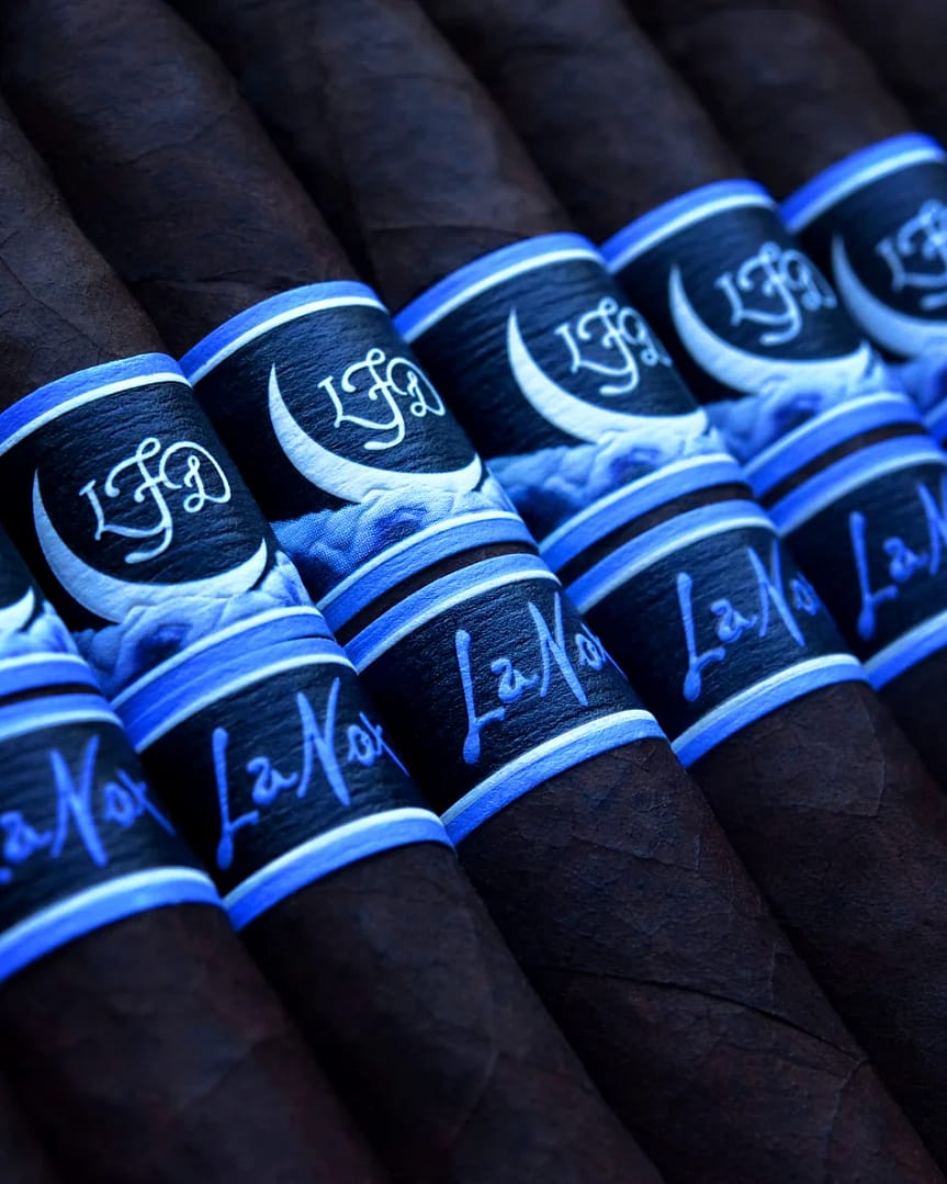 La Flor Dominicana La Nox cigar with a dark, oily wrapper and a striking deep blue and black band featuring a moonlit night design