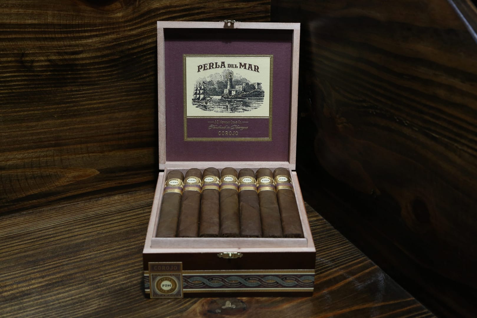 Open box of Perla Del Mar Corojo cigars neatly arranged with reddish-brown wrappers