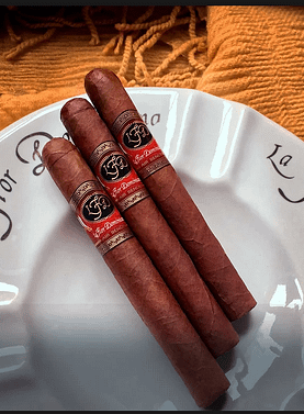 Three La Flor Dominicana Air Bender Double Press cigars resting elegantly on a ceramic dish, showcasing their box-pressed shape and rich brown wrappers.