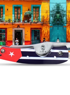 Rami’s Havana Edge Cigar Knife with Cuban-themed handle, folded and displayed in front of a colorful Cuban street building