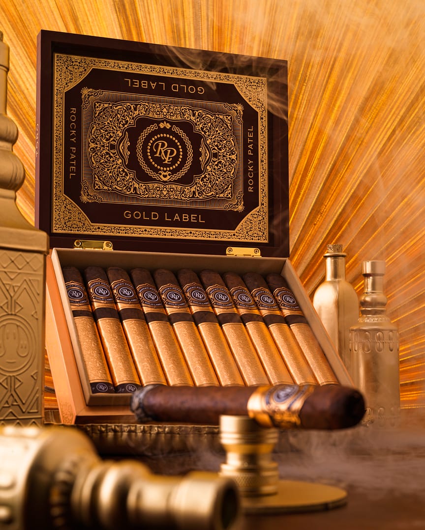 Open box of Rocky Patel Gold Label cigars, showcasing perfectly arranged cigars with elegant, gold-accented packaging.