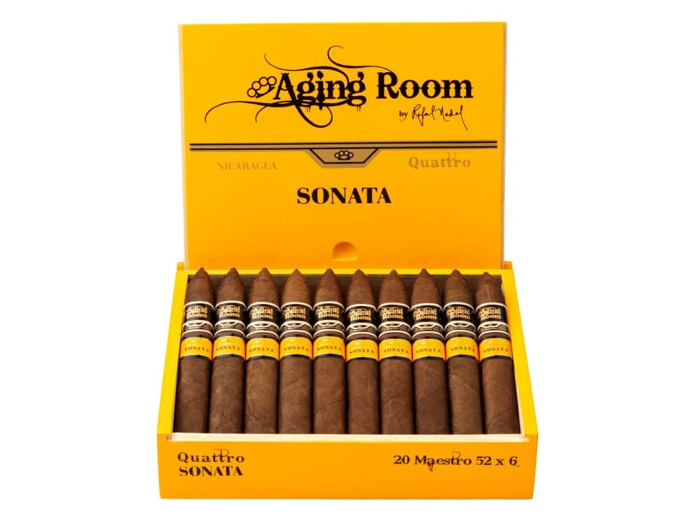 Open box of Aging Room Quattro Sonata Maestro cigars with reddish-brown wrappers and gold-trimmed bands
