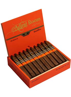 Aging Room Quattro Nicaragua cigar with dark wrapper and gold-accented band resting on wood